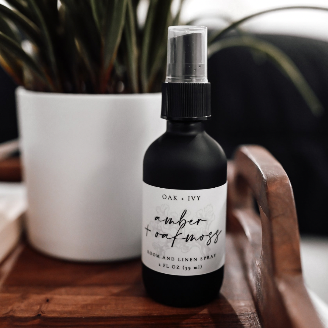 Aesthetic amber & oakmoss room spray next to an indoor plant